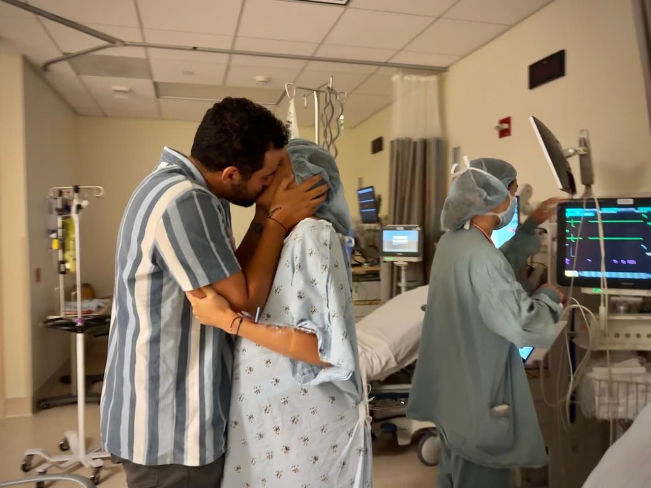 A couple sharing a kiss in the operating room before a cesarean birth