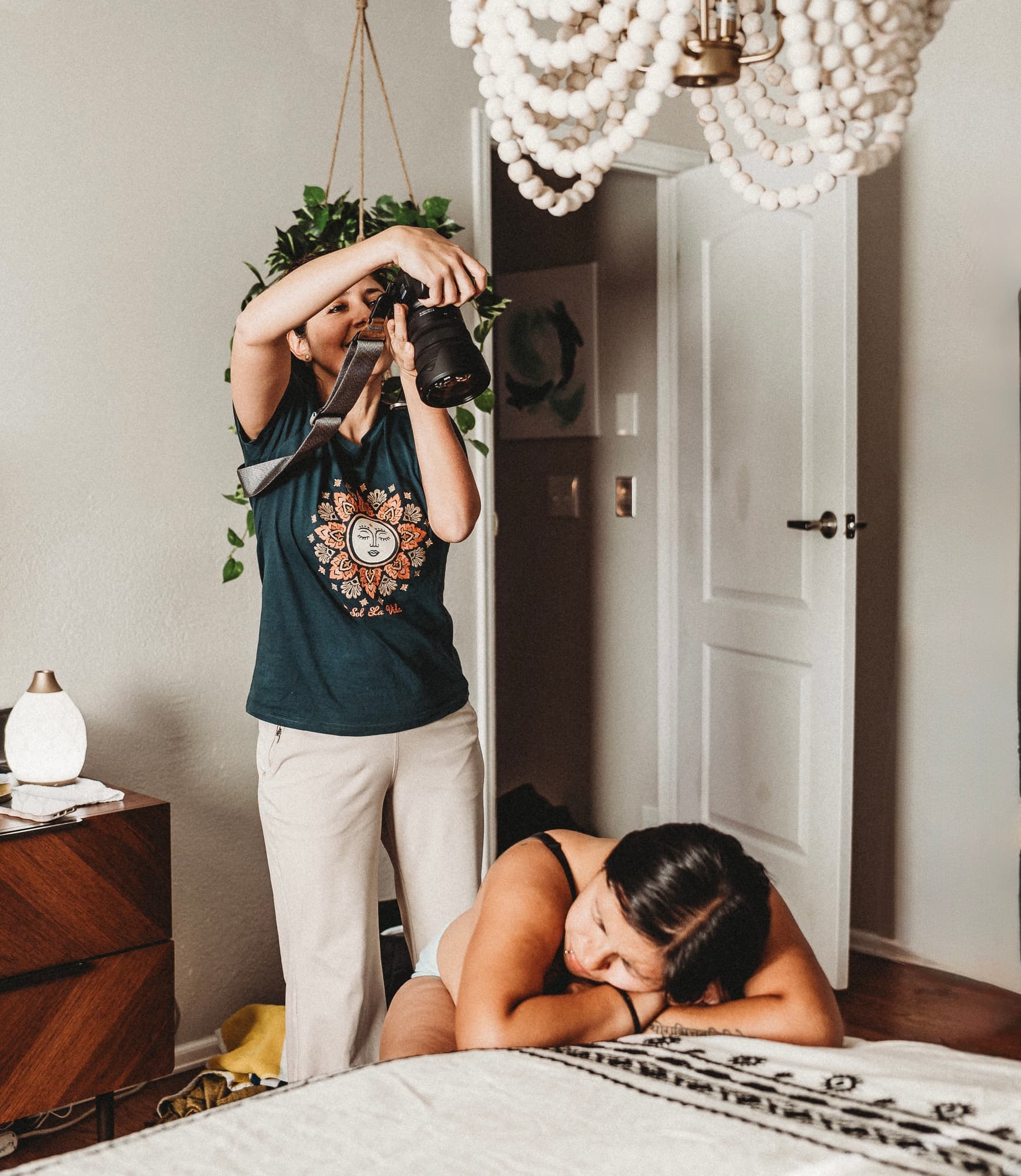 Maribel photographing a laboring mother resting her head on the bed at home