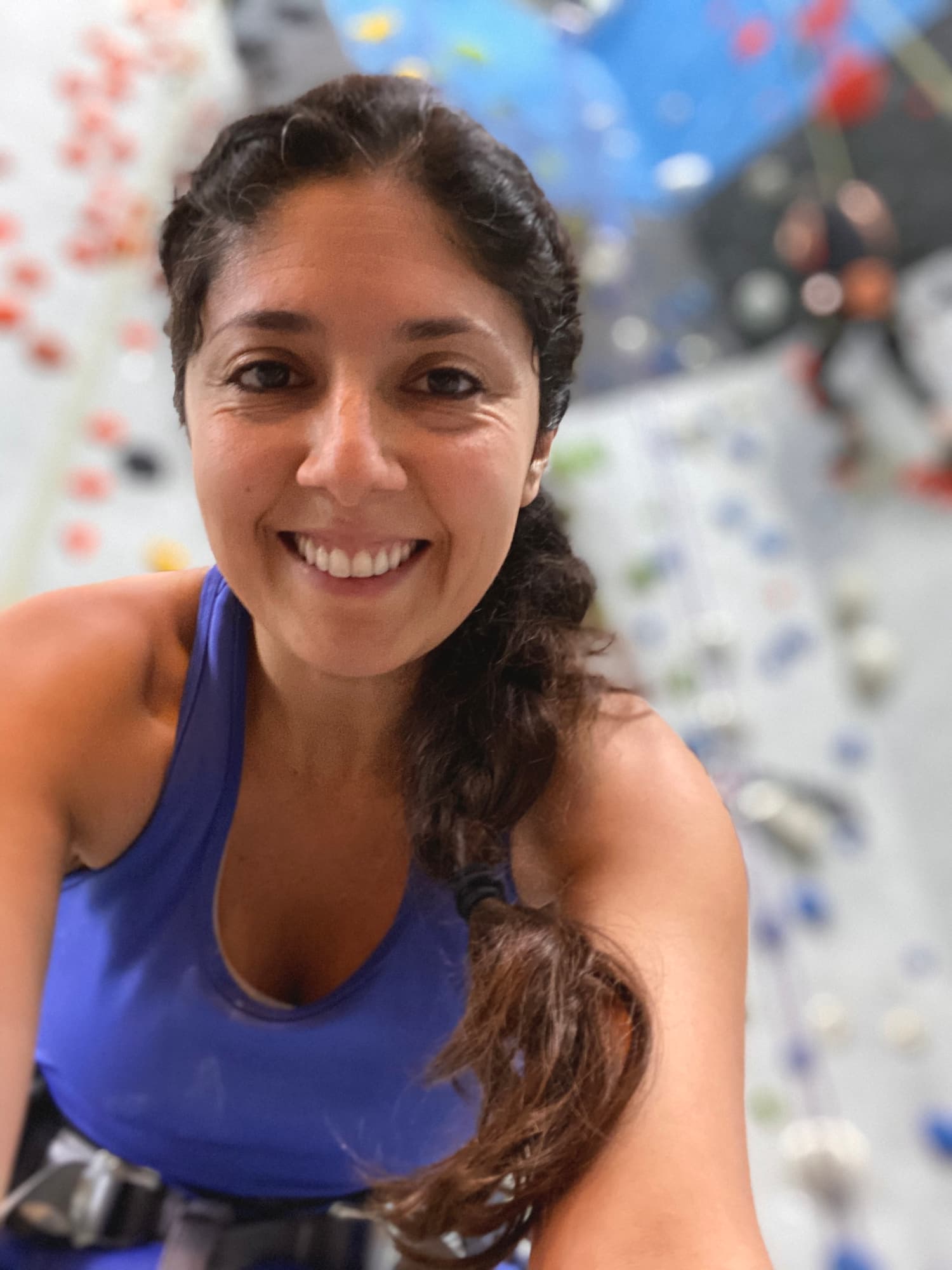 Maribel smiling at an indoor rock-climbing gym