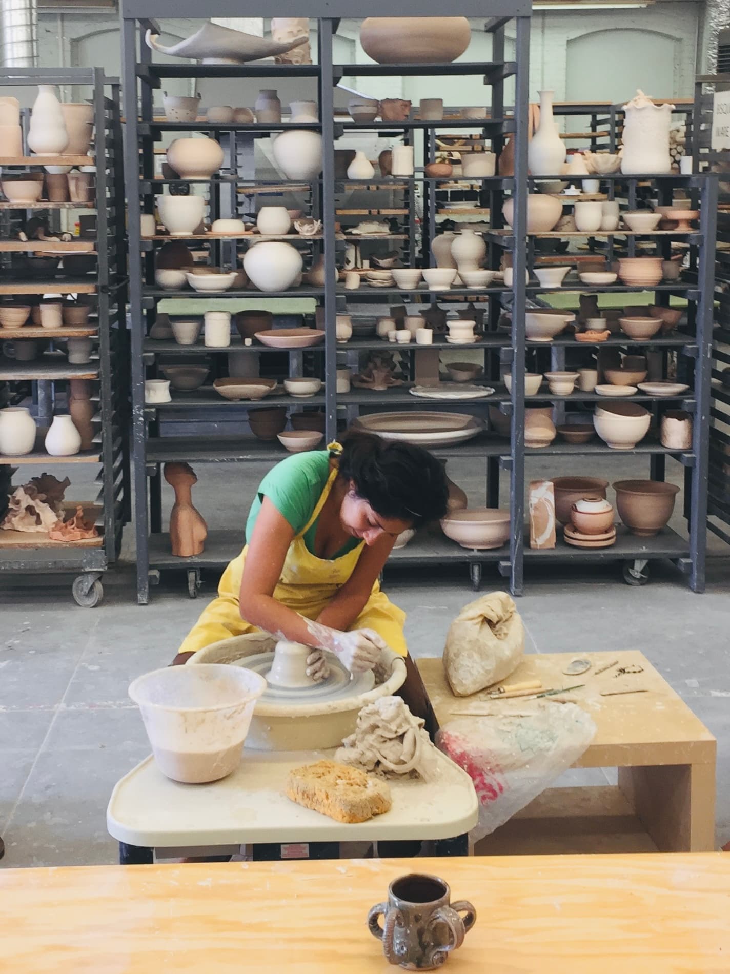 Maribel throwing a pot at the wheel in a ceramics studio